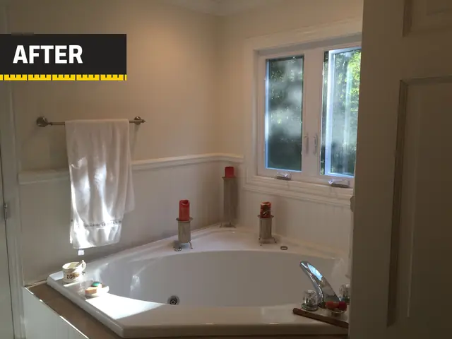 A bathroom we remodeled: corner soaking tub under the window, with white wainscoting