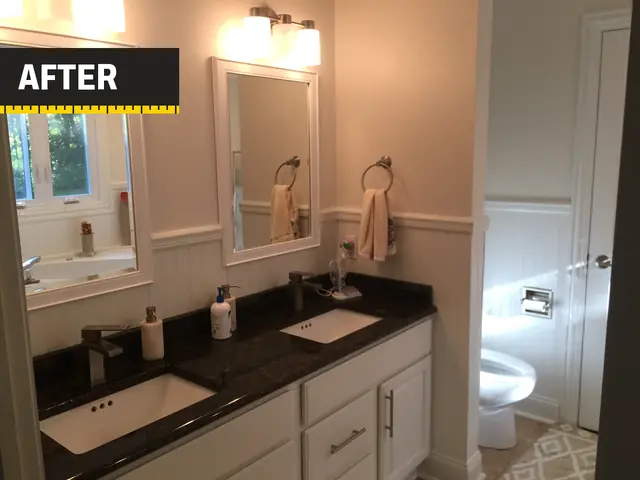 The same bathroom: double vanity with white cabinets, a dark stone top and two mirrors